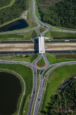 Completed I-4 at SR 557 Interchange looking north. The red truck aprons along the inside lanes of the roundabouts are designed to support the weight of larger trucks and help long vehicles turn safely through the roundabouts. The truck cab stays in the travel lane, but the tractor can safely track along the apron.